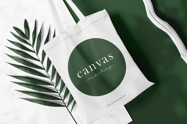 Free Clean Minimal Bag Canvas Mockup On Top Marble With Leaves And Stick Background. Psd File. Psd