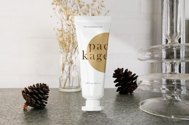 Free Clean Minimal Cream Tube Packaging Mockup Standing On Grey Marble With Pine Flower Background. Psd File. Psd