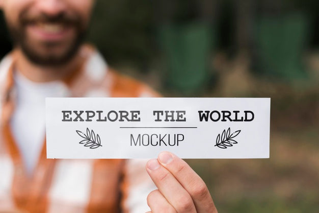 Free Front View Of Defocused Smiley Man Holding A Piece Of Paper While Camping Psd