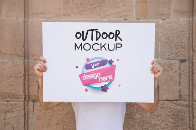 Free Man Presenting Poster Mockup In Front Of Brick Wall Psd
