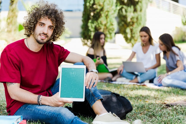 Free Man Showing Tablet Mockup In Park Psd