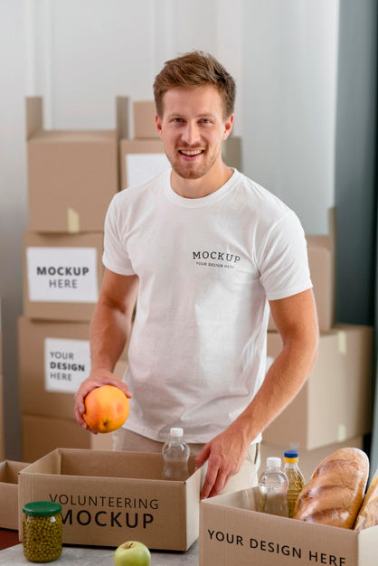 Free Smiley Male Volunteer Preparing Donation Box With Provisions Psd