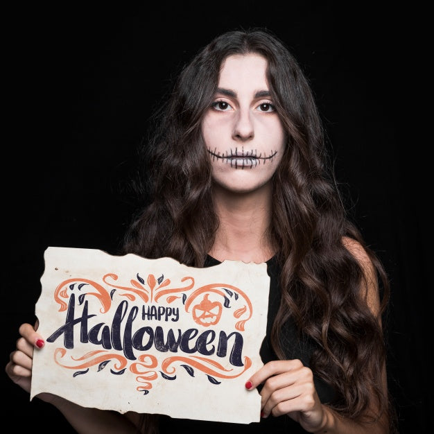 Free Woman Holding Paper With Halloween Lettering Psd