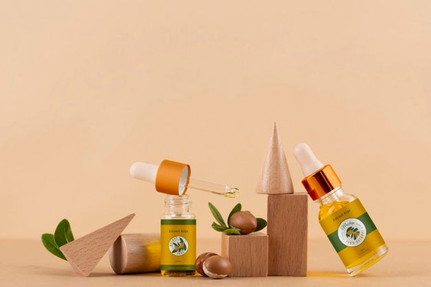Free Argan Oil Cosmetic Bottle Mock-Up With Wooden-Shaped Podium And Kernels Psd