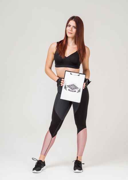 Free Athletic Woman In Gym Clothes Holding Notepad Psd