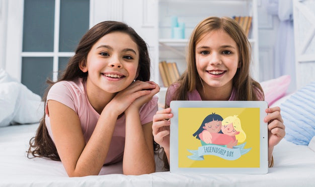 Free Best Friends Smiling While Looking At The Camera With Tablet Mock-Up Psd