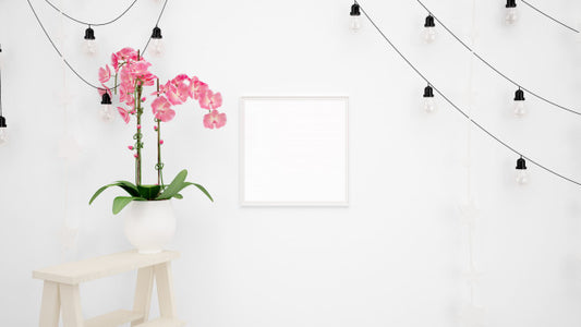 Free Blank Photo Frame Mockup With Lamps Hanging On White Wall And Beautiful Decorative Pink Flower Psd