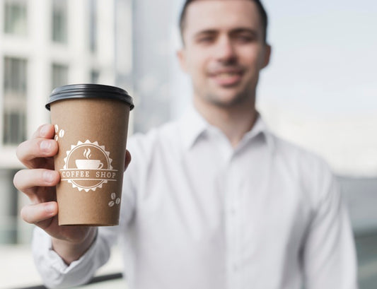 Free Business Man Holding Up A Coffee Cup Mock-Up Psd