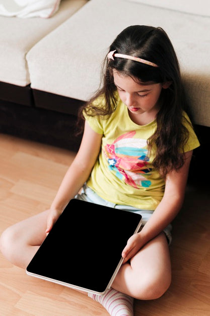 Free Child Sitting On A Floor With A Digital Tablet In Her Hands Psd