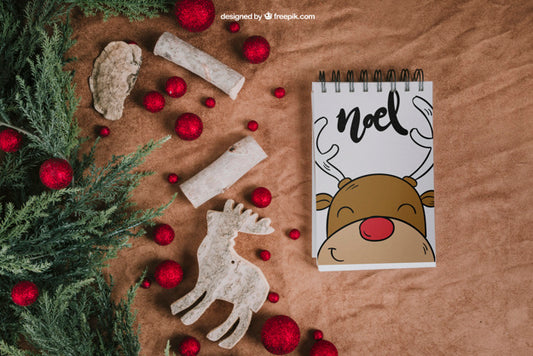 Free Christmas Mockup With Notepad Next To Balls And Reindeer Psd