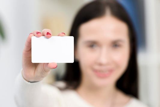Free Woman Holding a Business Card PSD Mockup in a Hand