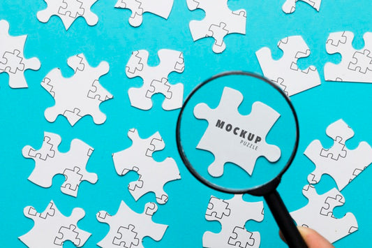 Free Close-Up Man With Magnifying Glass And Pieces Of Puzzle Psd
