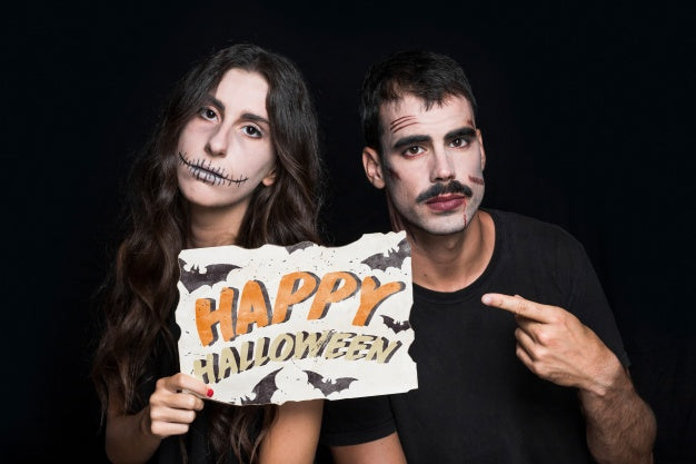 Free Couple Holding Paper With Halloween Lettering Psd