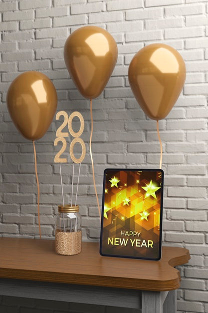 Free Decorations On Table Beside Tablet With Message For New Year Psd