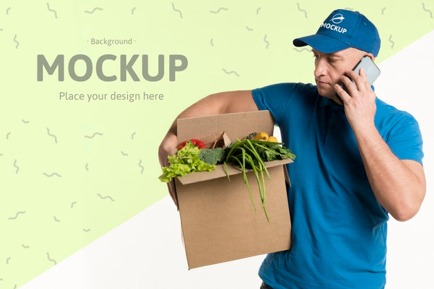Free Delivery Man Holding A Box Full With Vegetables While Talking On The Phone Psd