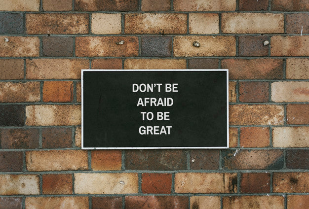 Free Don' Be Afraid To Be Great Board Mockup On A Brick Wall Psd