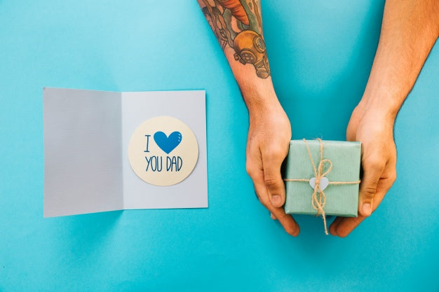 Free Fathers Day Mockup With Card And Hands Holding Present Box Psd