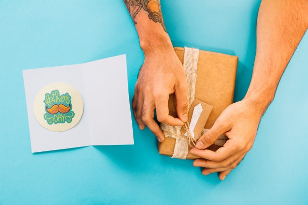 Free Fathers Day Mockup With Card And Hands Preparing Present Box Psd