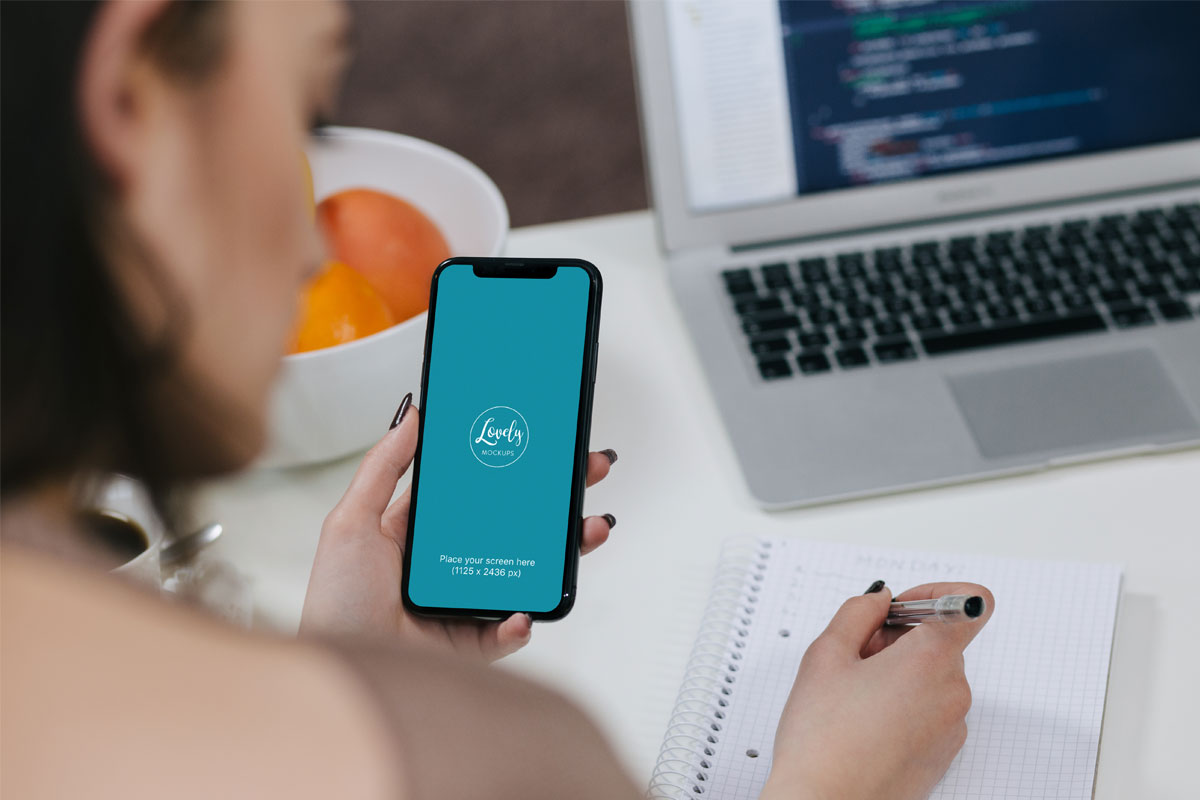 Free Woman Holding iPhone X Mockup and Taking Notes