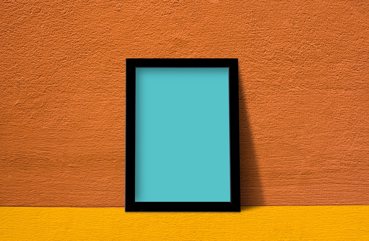 Free Frame Mockup Against An Orange Wall