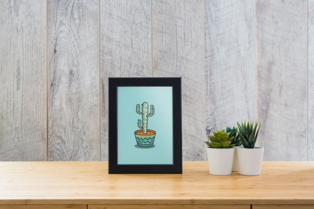 Free Frame Mockup On Table With Plants Psd