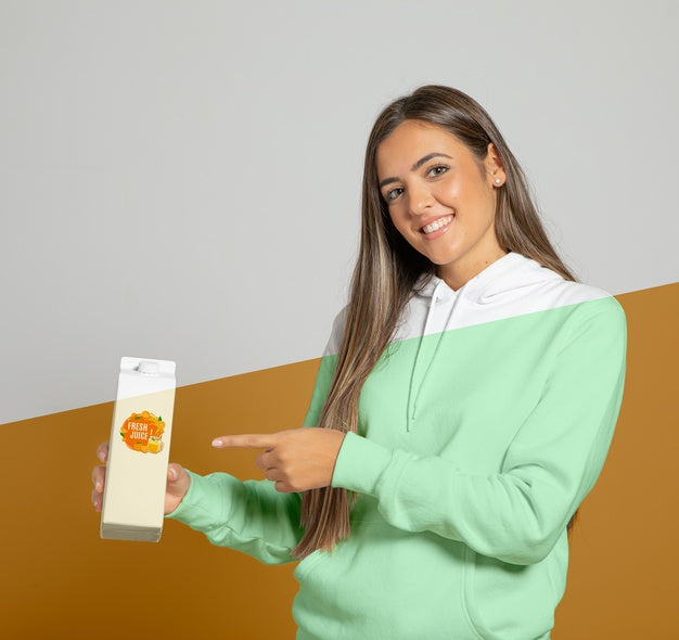 Free Front View Of Woman In Hoodie Pointing At Juice Carton Psd