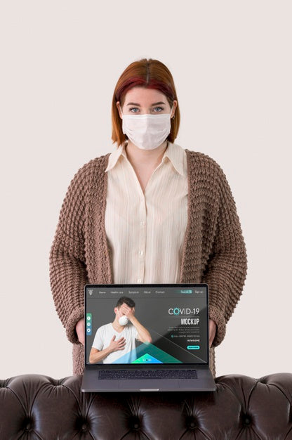 Free Front View Of Woman With Masks Holding Laptop Psd