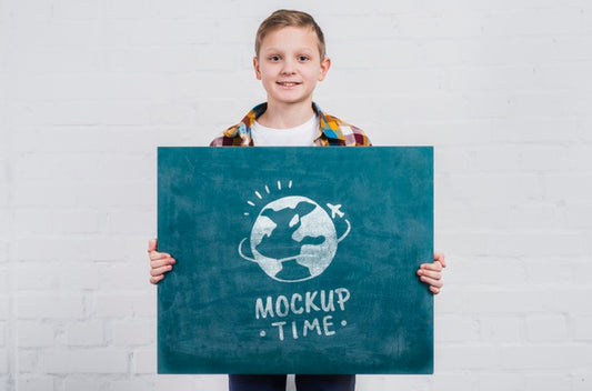 Free Front View Young Boy Holding Mock-Up Sign Psd