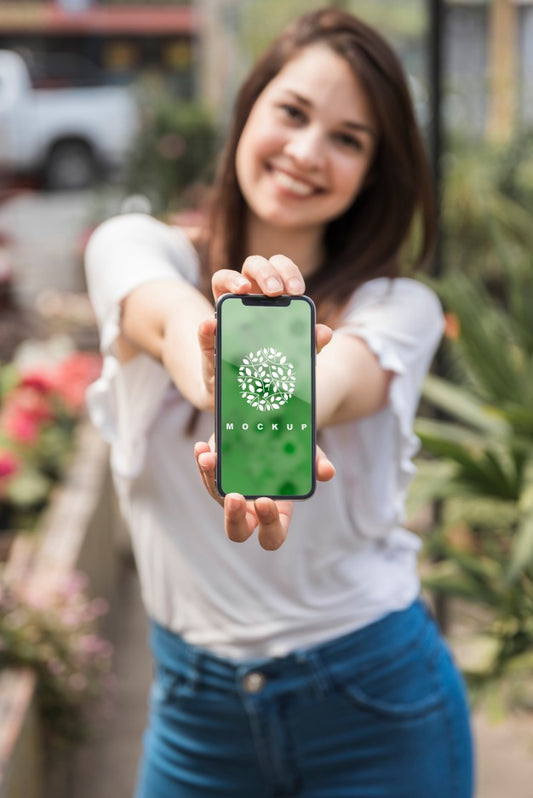 Free Girl Holding Smartphone Mockup With Gardening Concept Psd