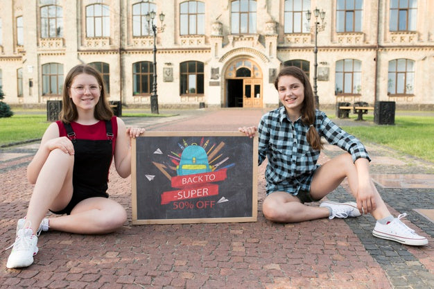 Free Girls Sitting While Holding A Blackboard Mock-Up Psd