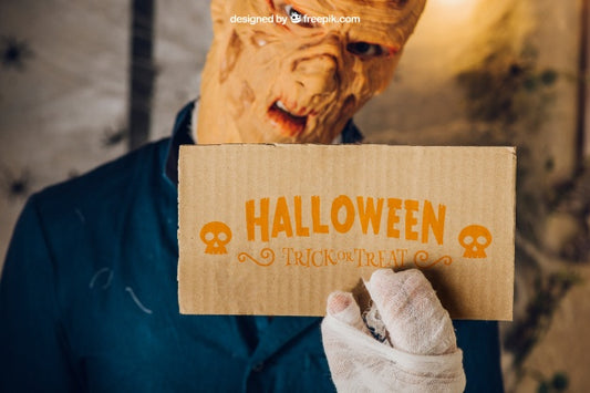 Free Halloween Mockup With Zombie Holding Cardboard Psd
