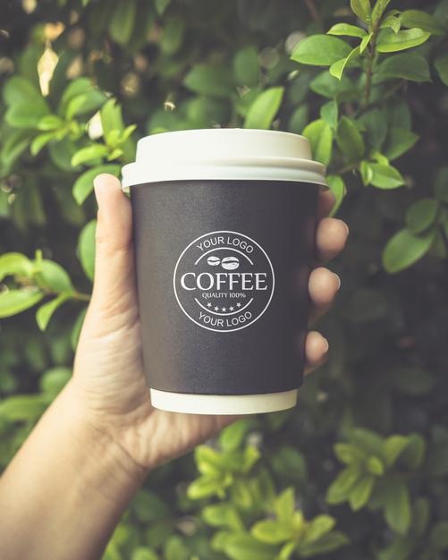Free Hand Holding A Coffee Paper Cup Mockup Psd