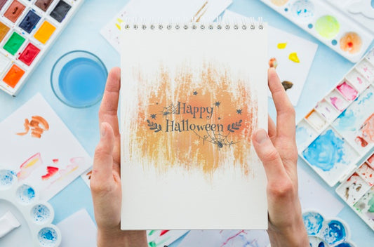Free Hands Holding Notebook With Halloween Message Psd