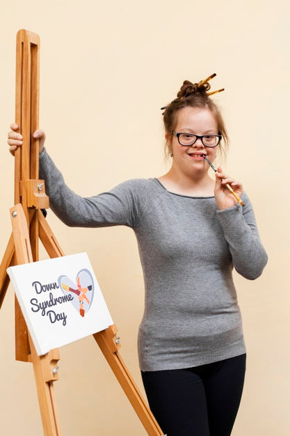 Free Happy Girl With Down Syndrome Posing With Canvas Mock-Up Psd