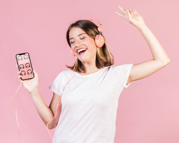 Free Happy Young Woman With Headphones Holding A Cellphone Mock-Up Psd