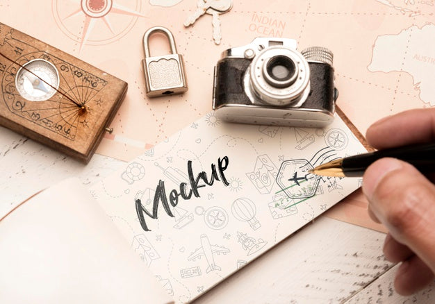 Free High Angle Of Person Writing On Paper With Camera And Compass For Traveling Psd