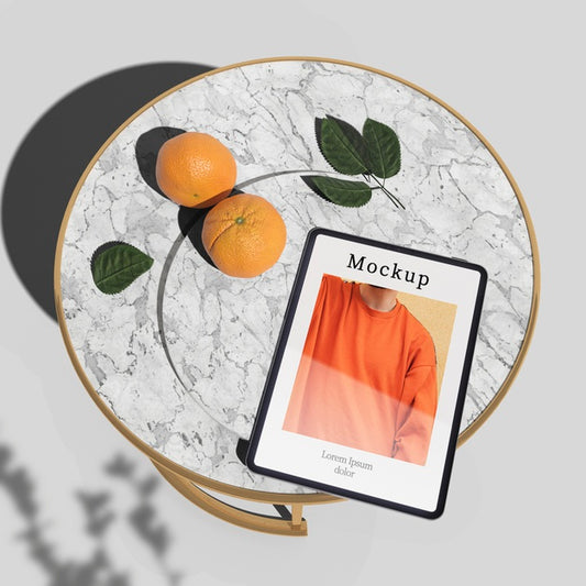 Free High Angle Of Tablet On Table With Oranges And Leaves Psd