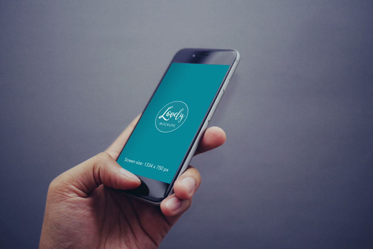 Free iPhone Mockup in Mans Hand with Gray Background