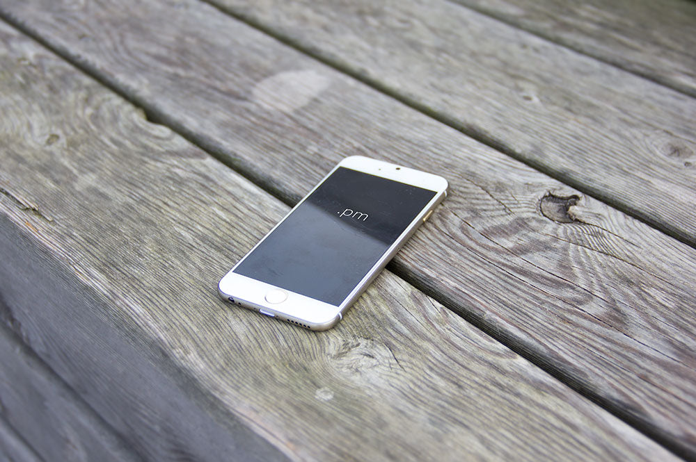 Free White iPhone 6 on a Wooden Table PSD Mockup