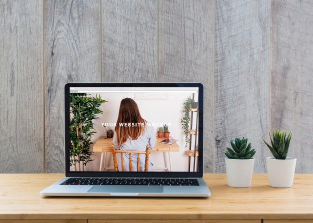 Free Laptop Mockup On Table With Plants Psd