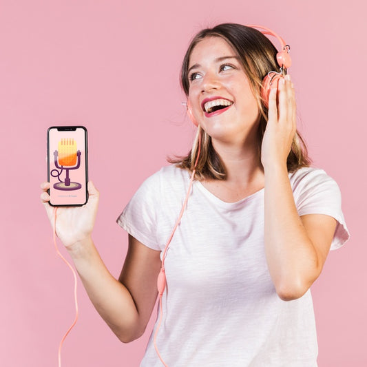 Free Laughing Young Woman With Headphones Holding A Cellphone Mock-Up Psd