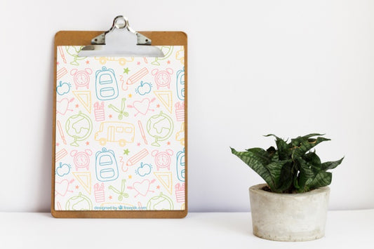Free Leaning Clipboard Next To A Plant Psd