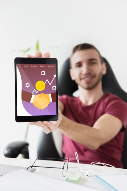 Free Male Student At Desktop Holding Tablet Psd