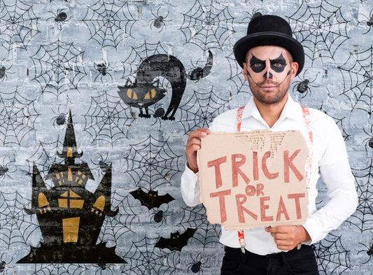 Free Male With Make-Up Holding A Card With Trick Or Treat Lettering For Halloween Psd