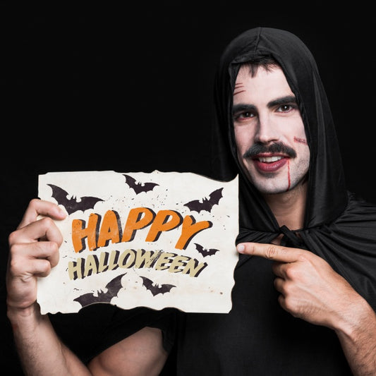 Free Man Holding Paper With Halloween Lettering Psd