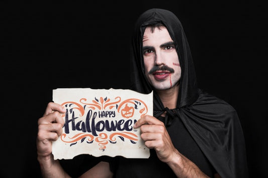 Free Man Holding Paper With Halloween Lettering Psd
