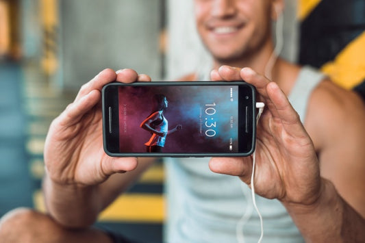 Free Man In Gym Holding Smartphone Mockup Psd