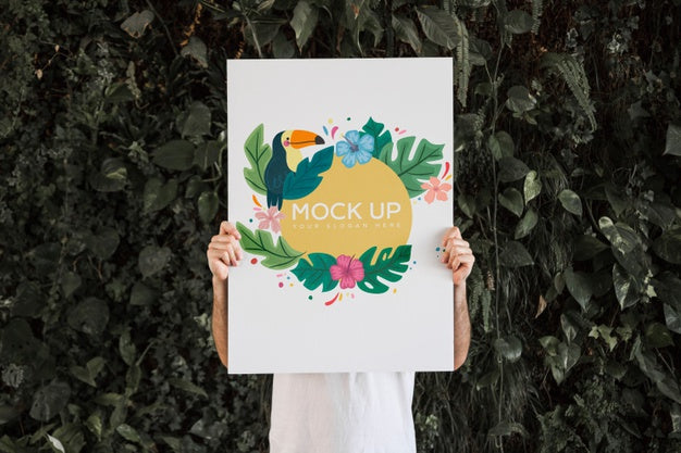 Free Man Presenting Poster Mockup In Front Of Leaves Psd