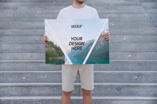 Free Man Presenting Poster Mockup In Front Of Stairs Psd