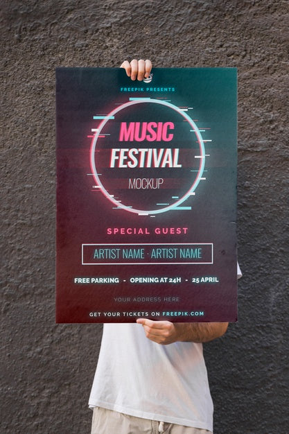 Free Man Presenting Poster Mockup In Front Of Wall Psd